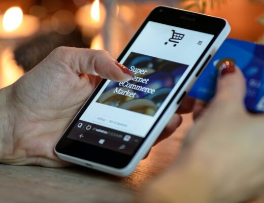 person using black and white smartphone and holding blue card