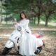 fashionable woman in bridal dress on motorcycle