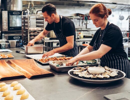 man and woman wearing black and white striped aprons cooking