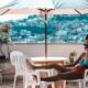 woman sitting on armchair under white patio umbrella