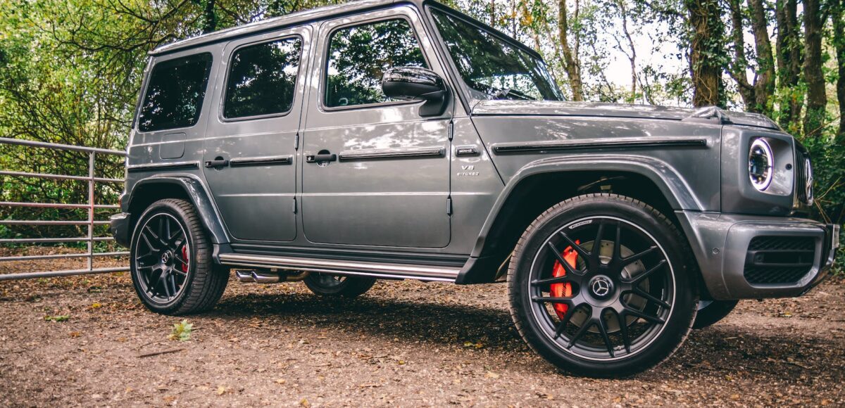 photo of mercedes benz g class parked on dirt road