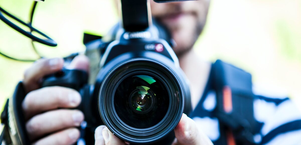 person holding canon dslr camera close up photo