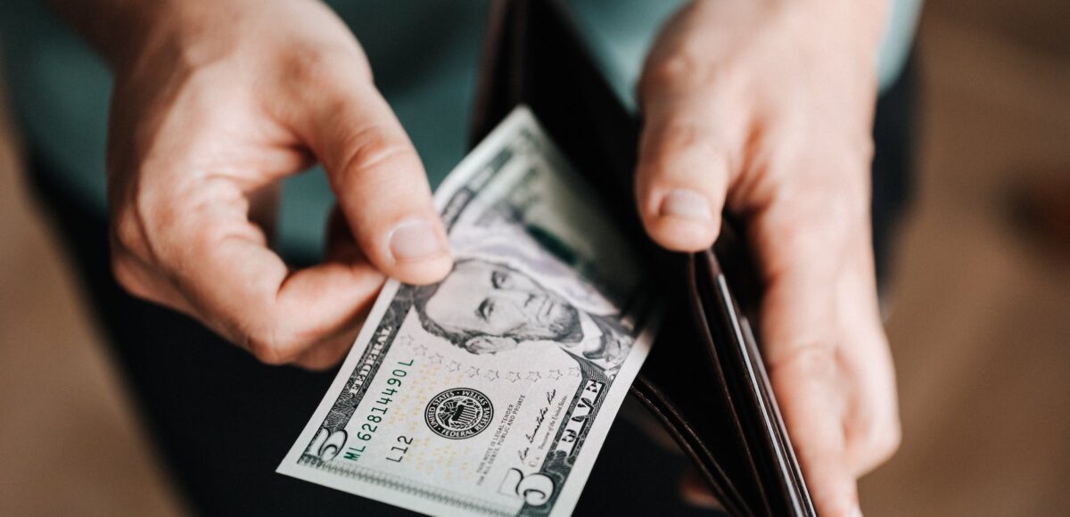 unrecognizable man holding wallet with money