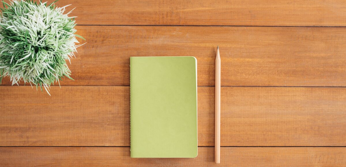 white notes beside a pencil on brown wooden surface