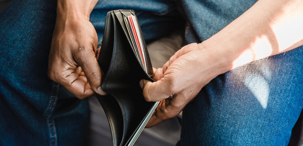 man looking at an empty wallet