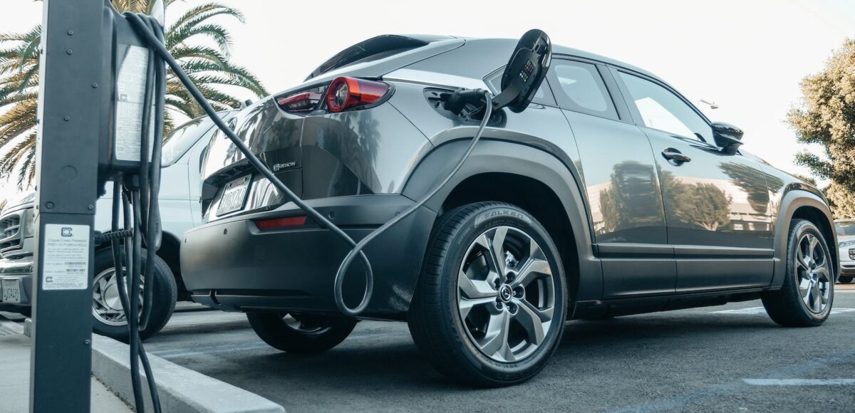 gray electric car parked on a charging bay