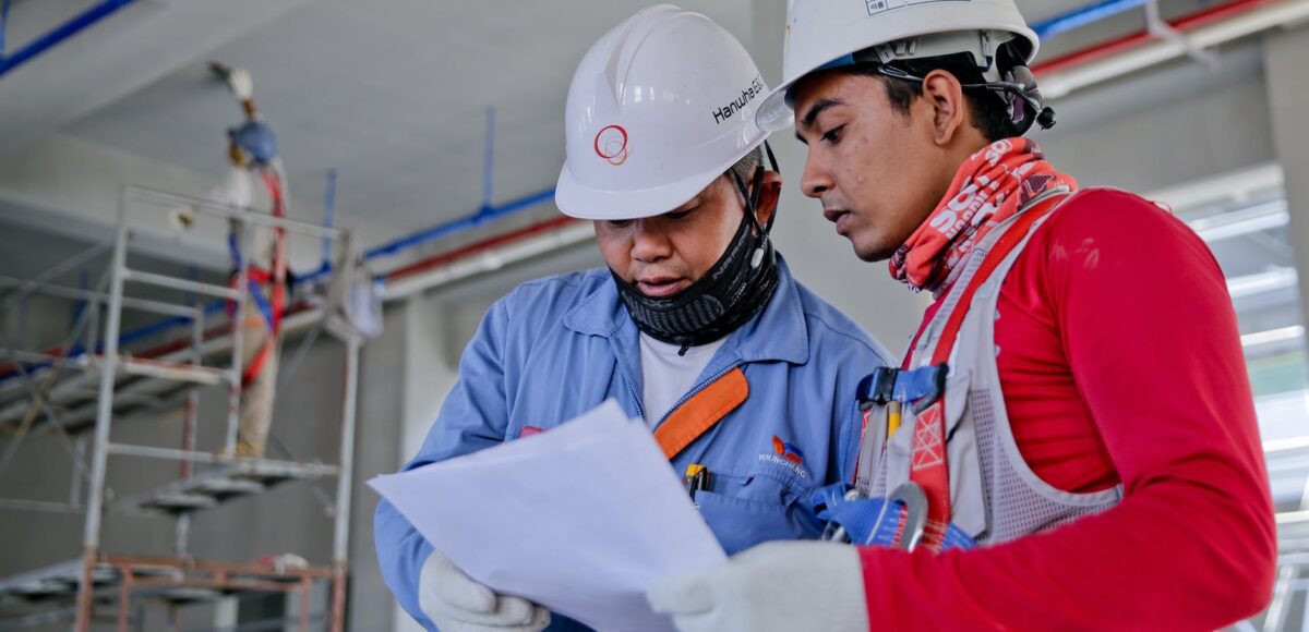 two man holding white paper