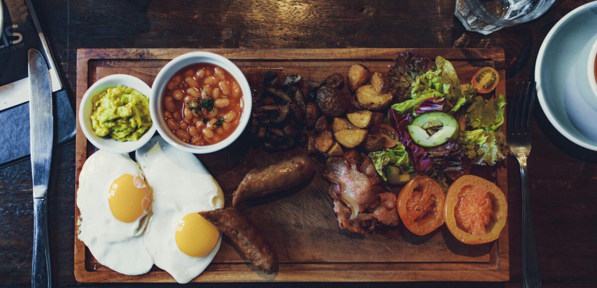 grilled vegetables and fried egg with beans and sausage