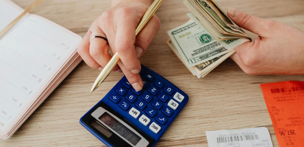 woman calculating money and receipts using a calculator