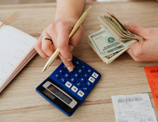 woman calculating money and receipts using a calculator